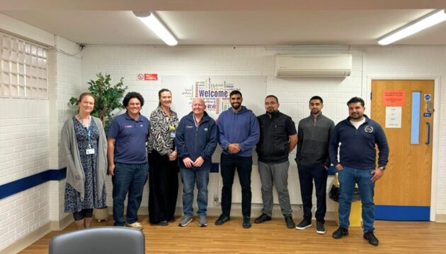 Eight people stood in a room